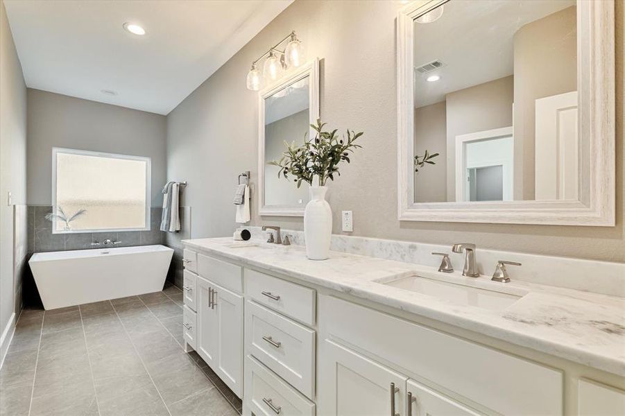 Bathroom featuring a bathing tub, vanity, and tile patterned floors