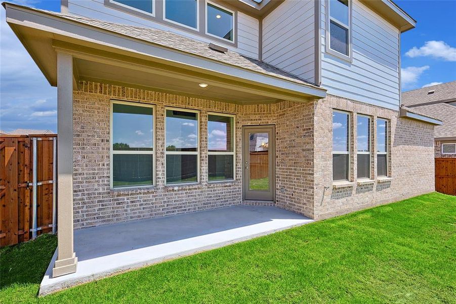 Rear view of property with a lawn and a patio area