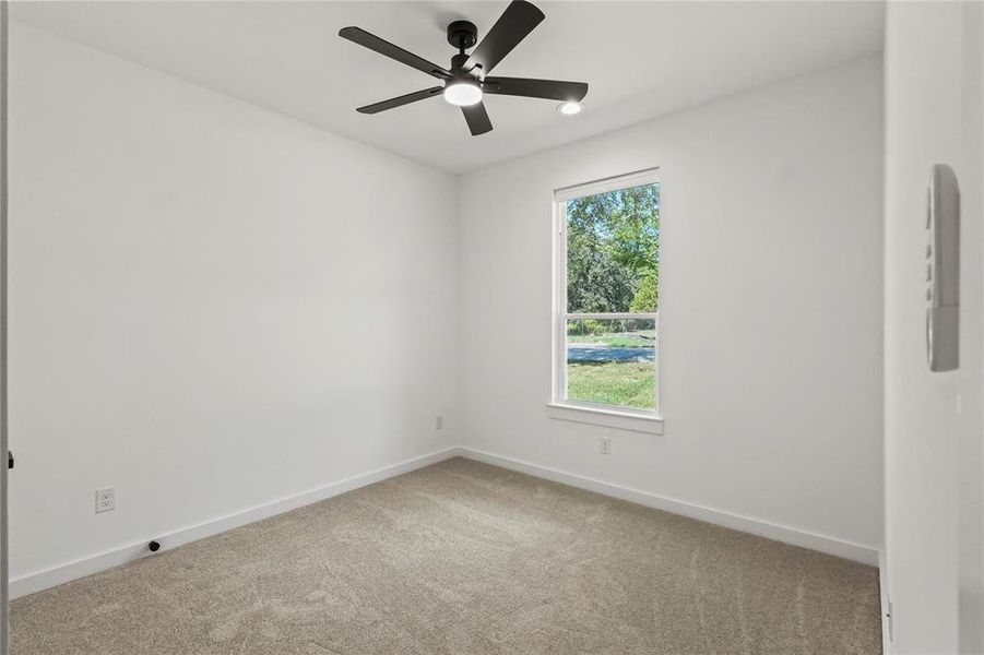 Spare room with ceiling fan and carpet flooring