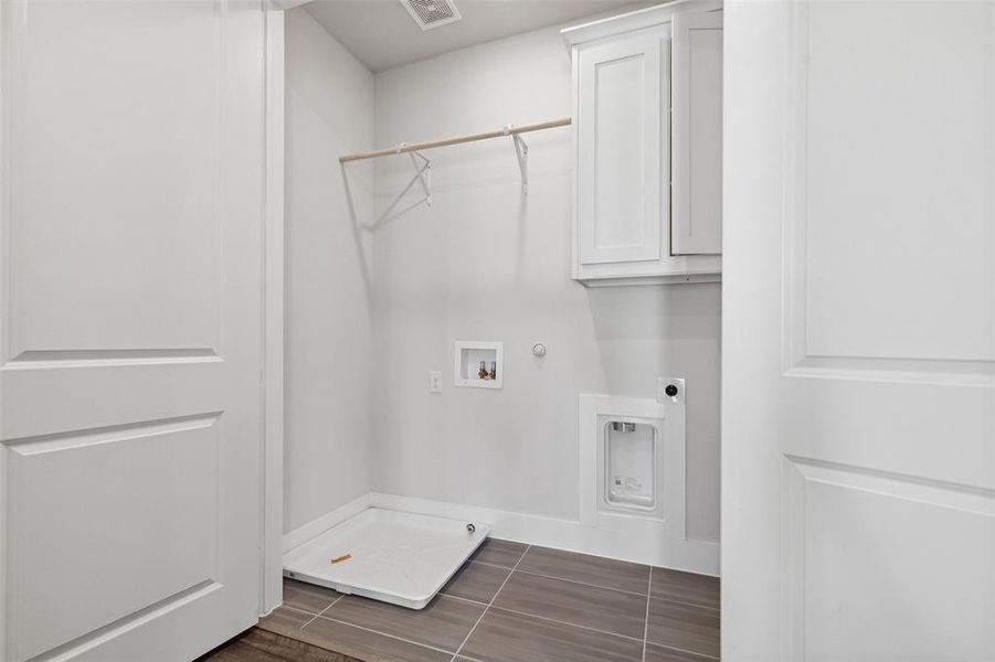 Laundry area featuring cabinets, electric dryer hookup, gas dryer hookup, tile floors, and washer hookup