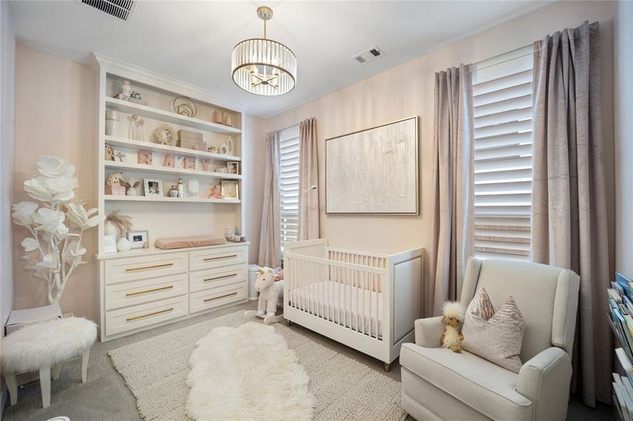 Bedroom with a nursery area and an inviting chandelier