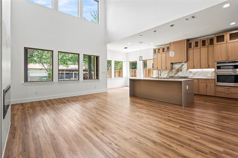 Kitchen with plenty of natural light, a center island with sink, and pendant lighting