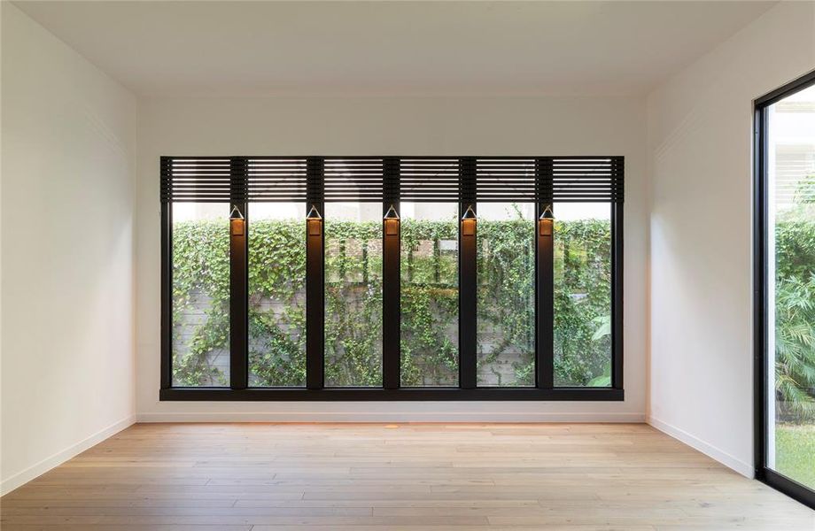 The living room has 2 walls of double-pane windows providing natural light and multiple views of a tropical mature garden.  The Boston Ivy and other  vines were planted in 2019 and provide a green privacy wall along the entire fence line.