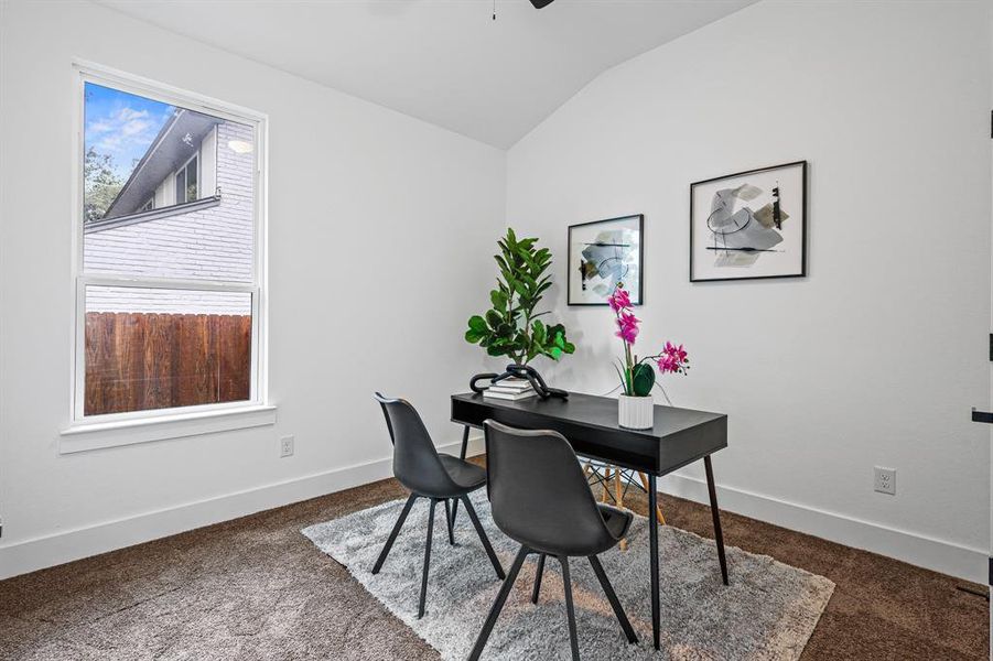 Carpeted office space featuring vaulted ceiling and ceiling fan