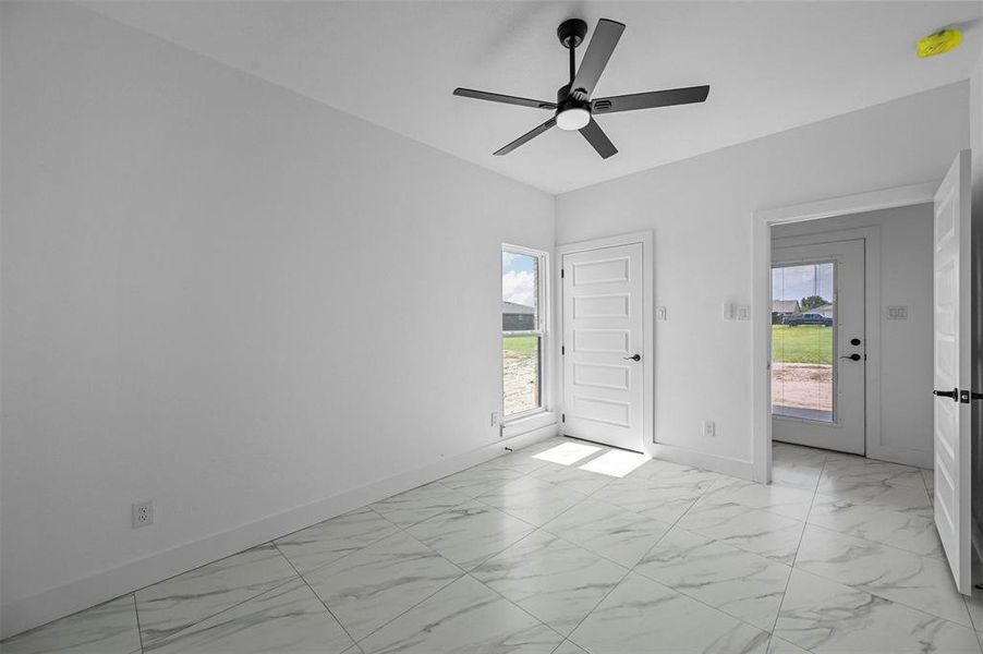 Foyer featuring light tile patterned floors and ceiling fan