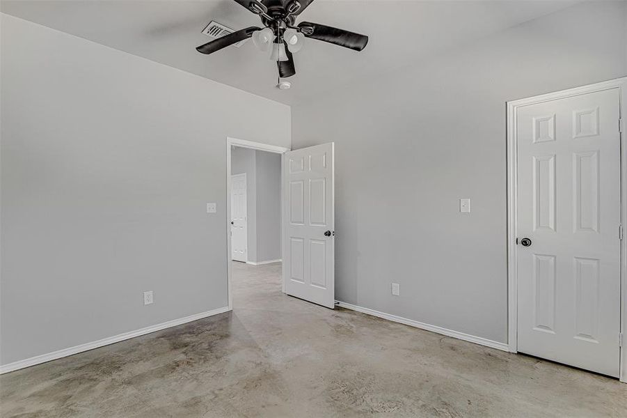 Unfurnished bedroom with concrete floors and ceiling fan