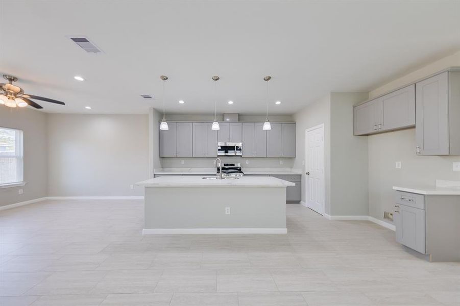 The spacious kitchen features a stunning quartz island that serves as both a functional workspace and a beautiful centerpiece. With its sleek surface and ample room for seating, the island is perfect for meal prep, casual dining, or gathering with family and friends. This elegant feature elevates the modern design of the kitchen while offering practical convenience.