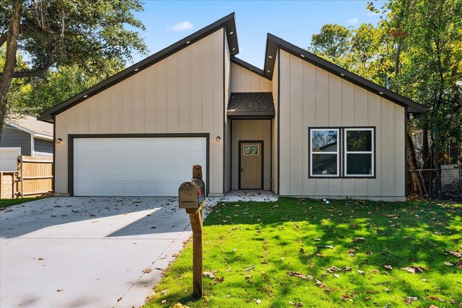 View of front of house featuring a garage and a front yard