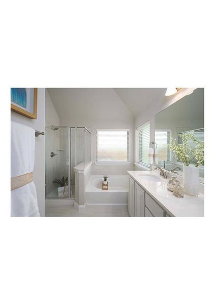 Bathroom featuring vanity, independent shower and bath, and vaulted ceiling