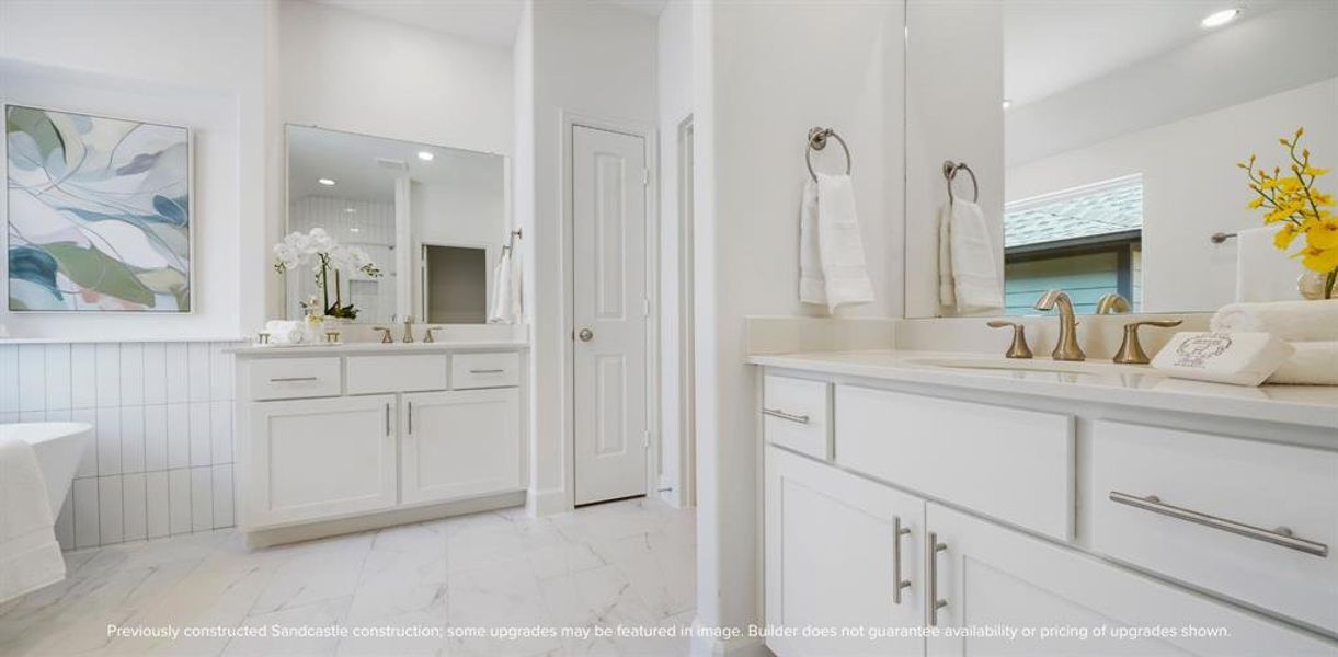 Spa-like Splendor: Dual vanities, a roomy linen closet, and a secluded water closet are set amid abundant space for an everyday spa experience right at home.