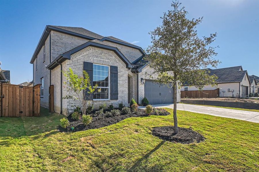 View of front of property featuring a front yard and a garage