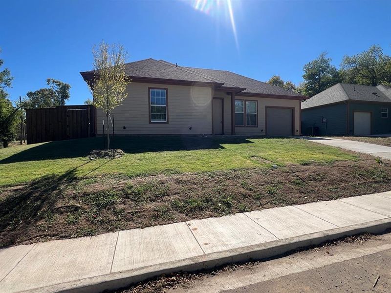 Single story home featuring a garage and a front yard