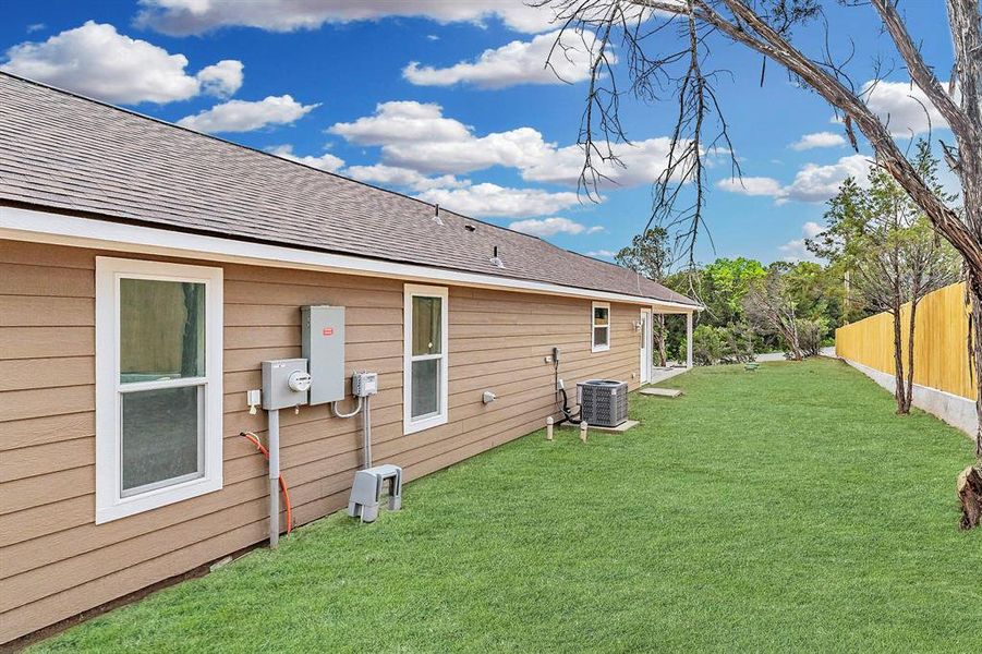 Back of house with cooling unit and a yard