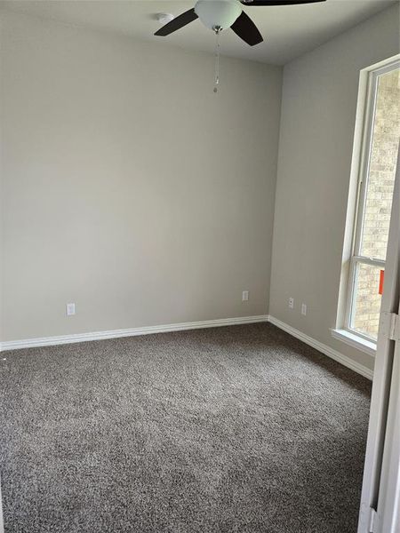 Spare room with dark colored carpet and ceiling fan