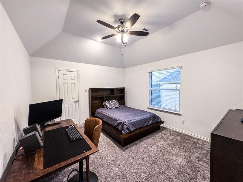 Bedroom featuring vaulted ceiling, carpet floors, and ceiling fan