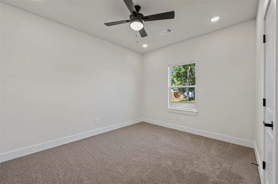 Carpeted spare room with ceiling fan