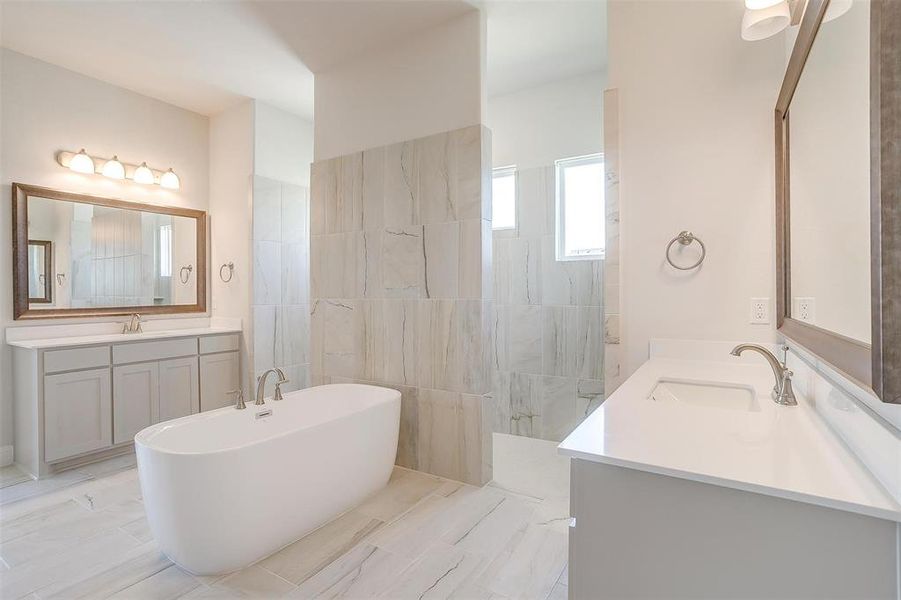 Bathroom featuring dual bowl vanity, tile patterned floors, and a tub