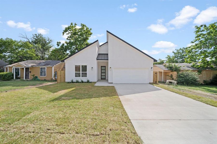 View of front of house with a front lawn and a garage