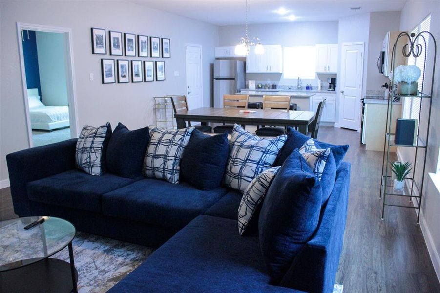 Living room with a notable chandelier, sink, and hardwood / wood-style floors