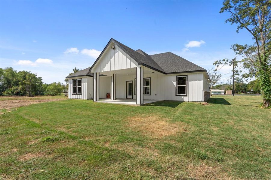 Rear view of house featuring a yard and a patio