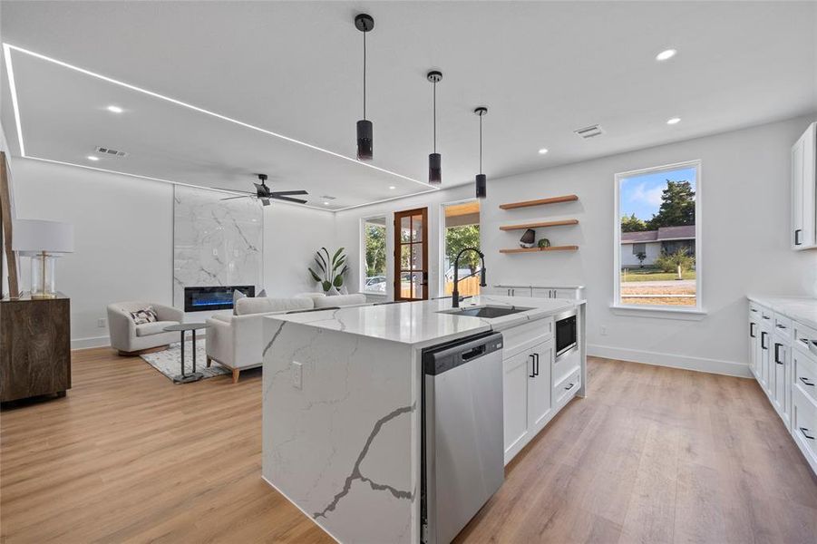 Kitchen featuring a kitchen island with sink, light wood-type flooring, sink, white cabinets, and appliances with stainless steel finishes