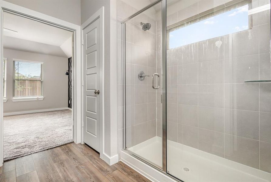 Bathroom featuring a shower with door and hardwood / wood-style floors