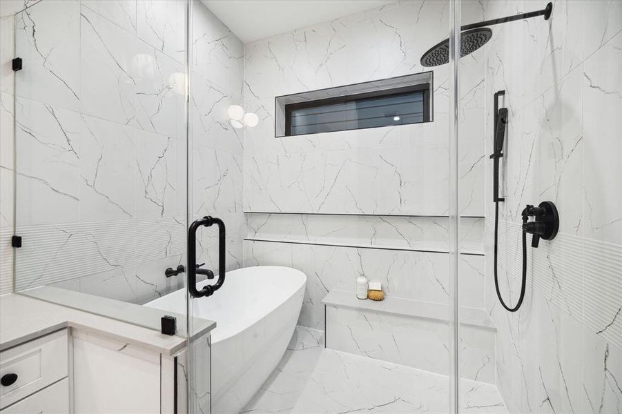 The Primary Bath also features a Walk-In Wet Room with a 59 " Soaking Tub, Wall Mounted Tub Faucet, a Bench and Shower Area with a Wall Mounted Shower and a Handheld Shower. Coordinating 12 x 24 Tile and a Frameless Glass Enclosure makes you feel like you are at the Spa.