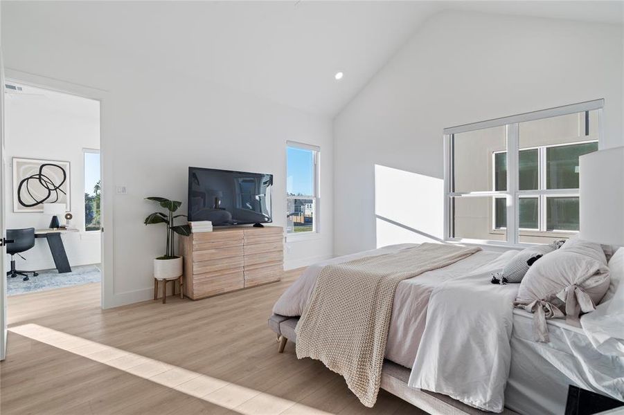 The primary bedroom extends effortlessly into an adjacent flex space, offering endless possibilities for work, relaxation, or hobbies. Large windows brighten the entire area, creating a connected and airy retreat.