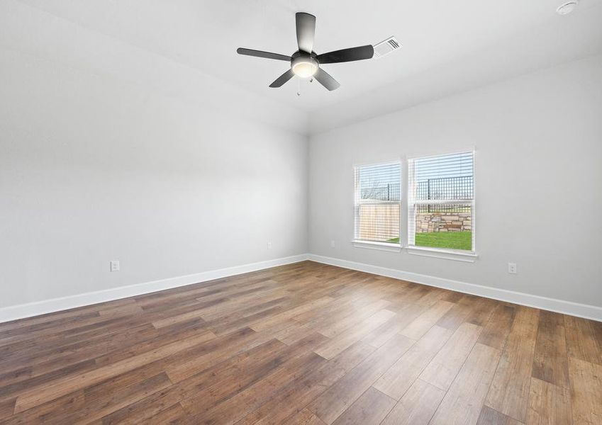 Master suite with high vaulted ceilings and two large windows, welcoming in ample natural light.