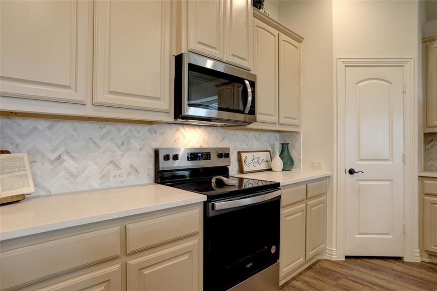 Kitchen with appliances with stainless steel finishes, tasteful backsplash, and light wood-type flooring