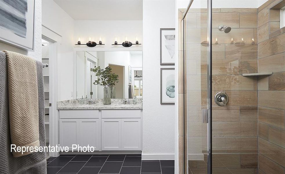 Bathroom with vanity, tile patterned floors, and a shower with door