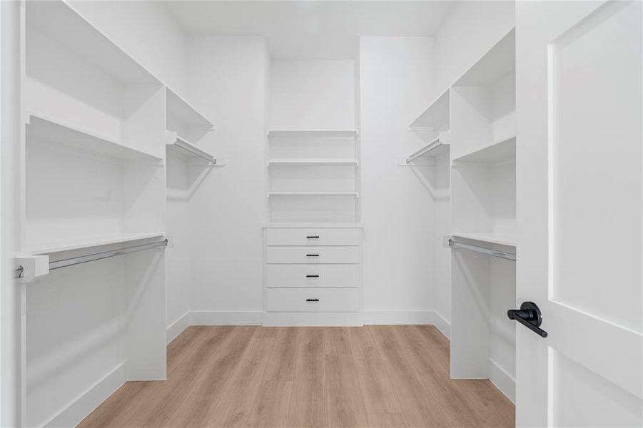 Designed for ultimate organization, this walk-in closet includes built-in drawers, multiple shelves, and hanging space, providing a clean and efficient storage solution for your wardrobe essentials.