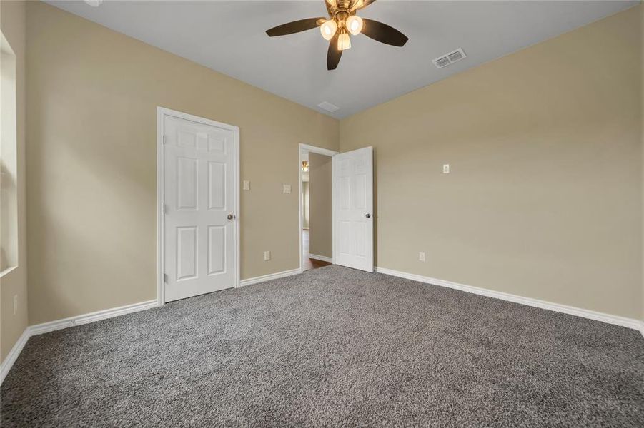 Unfurnished bedroom featuring ceiling fan and carpet flooring