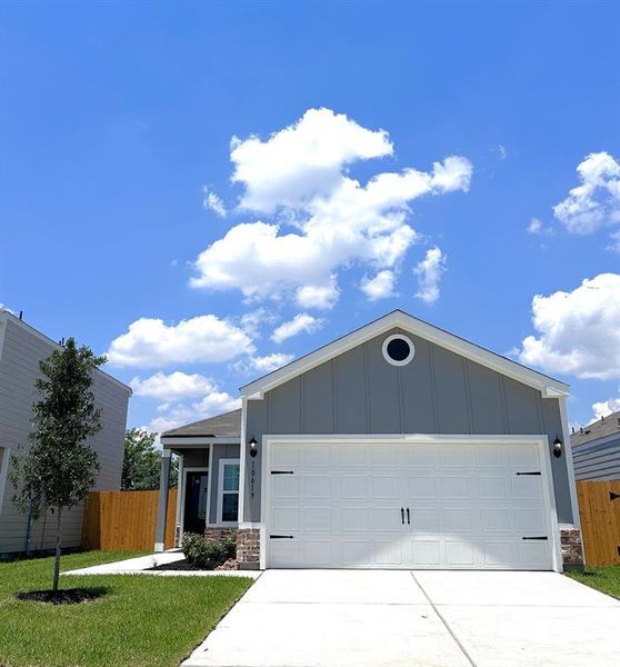 This home has a beautiful, modern design with garage door accents and a nice tree in the front yard to provide shade in the coming years.