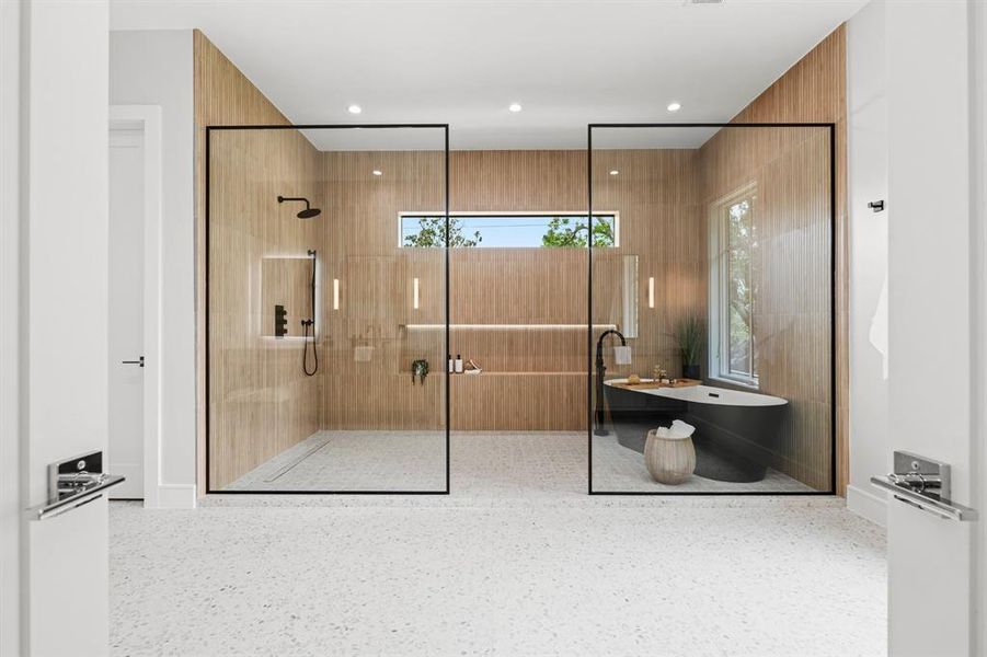 A luxurious primary bath featuring a glass encased extra large wet room.