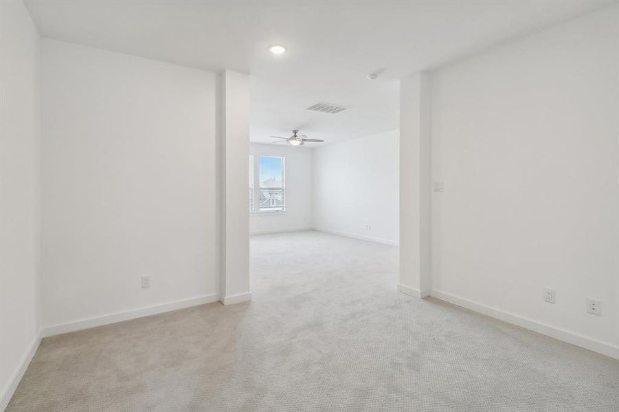 Carpeted empty room with ceiling fan