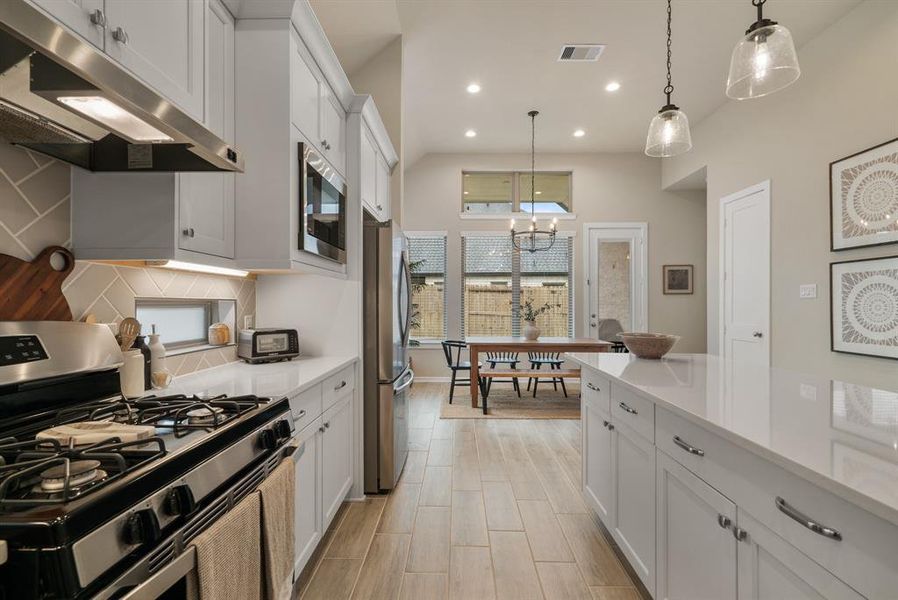 Gas range and wood tile flooring throughout.