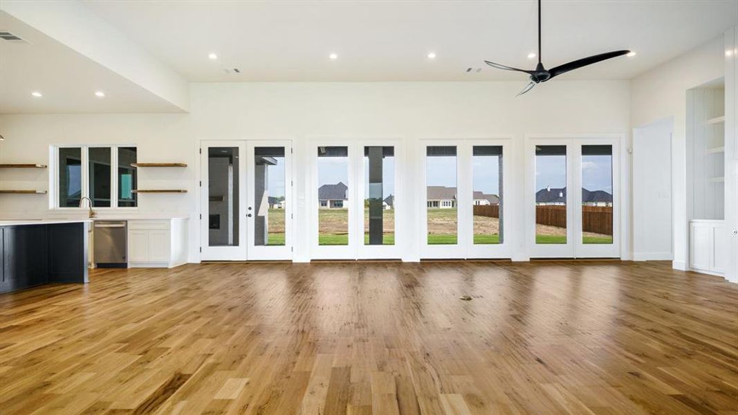 Unfurnished living room with light wood-type flooring and ceiling fan