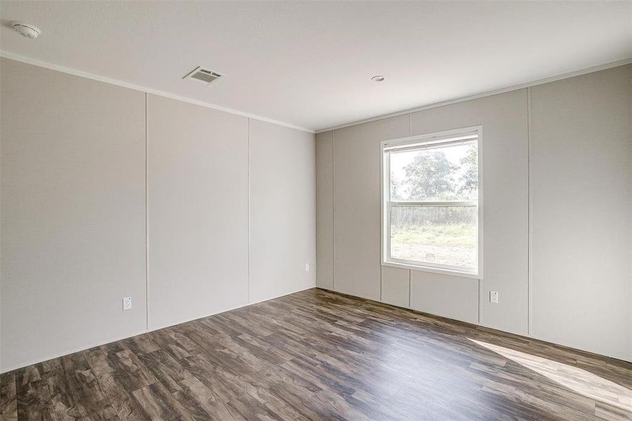 Empty room with crown molding and dark hardwood / wood-style floors