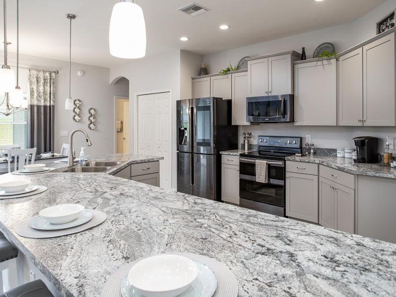 Your new gourmet kitchen has ample counter space, a walk-in pantry, and is fully open to the gathering room - Willow II with Loft home plan by Highland Homes