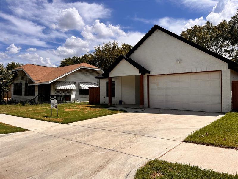 Ranch-style house featuring a garage and a front lawn