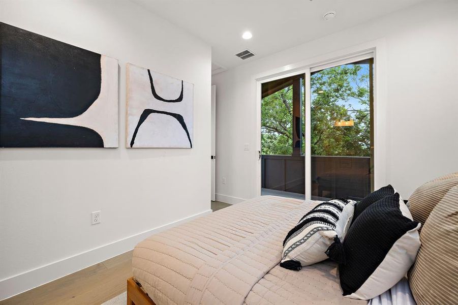 View of the primary bedroom looking toward the awesome covered balcony.