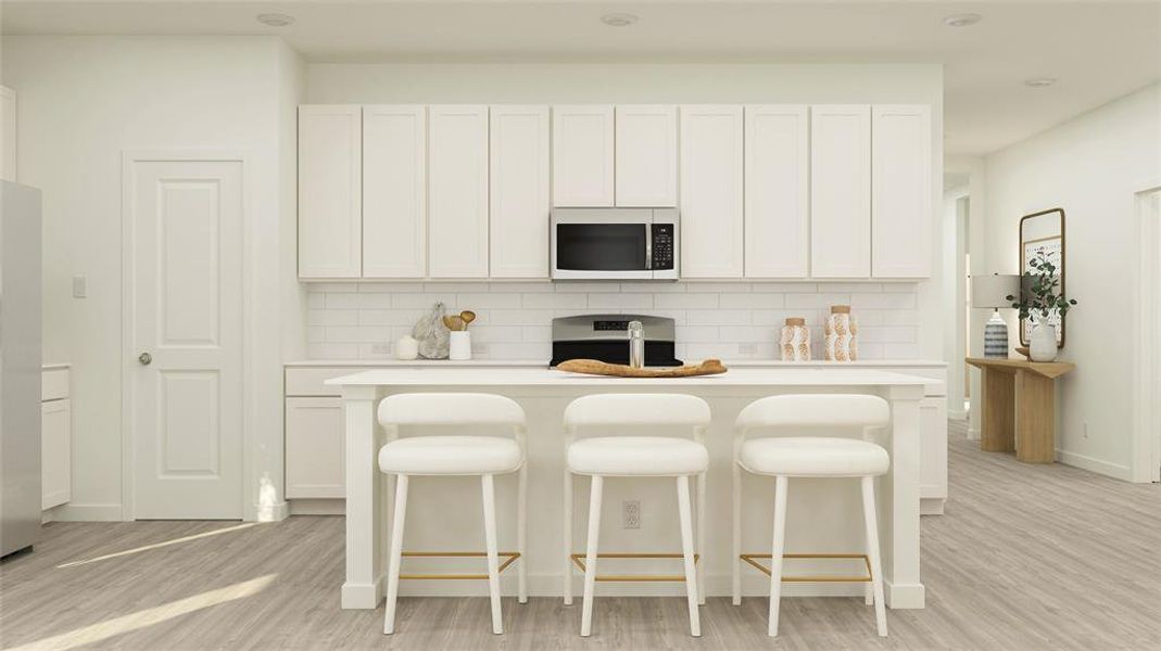 Kitchen featuring an island with sink, light hardwood / wood-style floors, white cabinetry, and appliances with stainless steel finishes