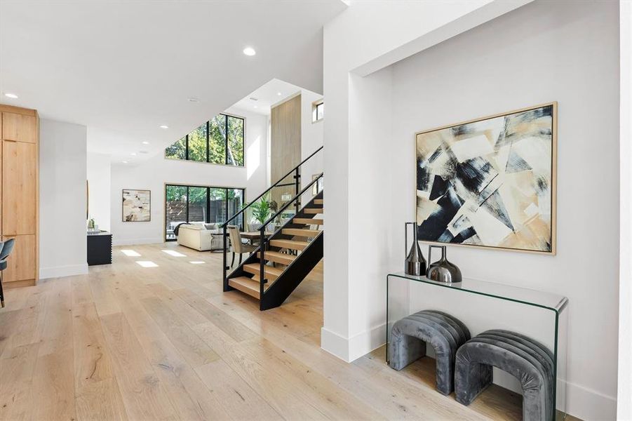 Staircase featuring a towering ceiling and hardwood / wood-style floors