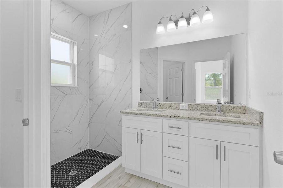 Double sink vanity and sunken tiled shower in primary bath