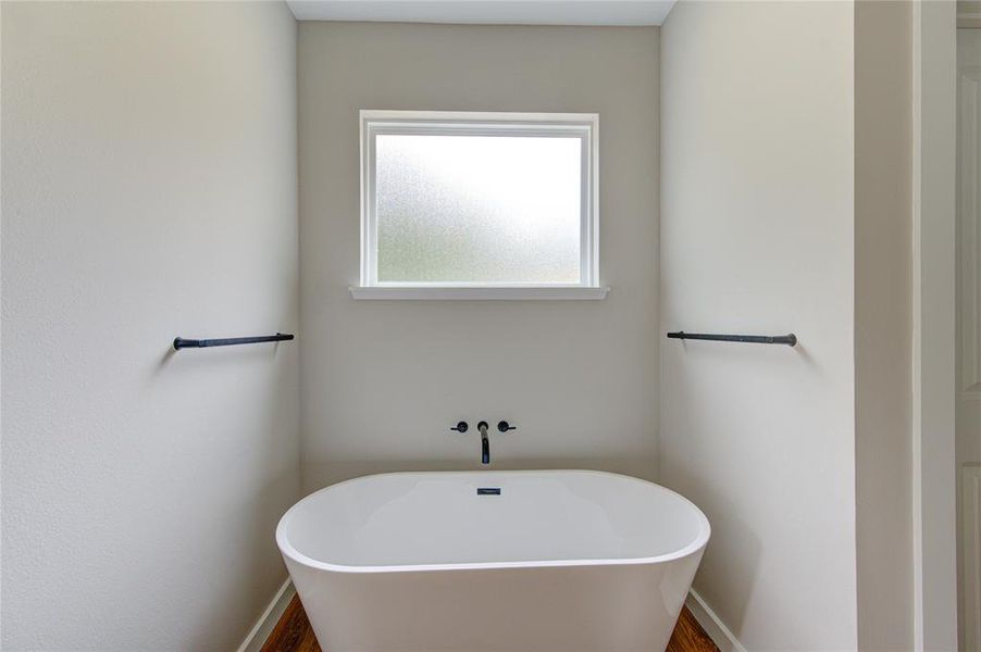 Large soaking tub under large opaque glass for privacy