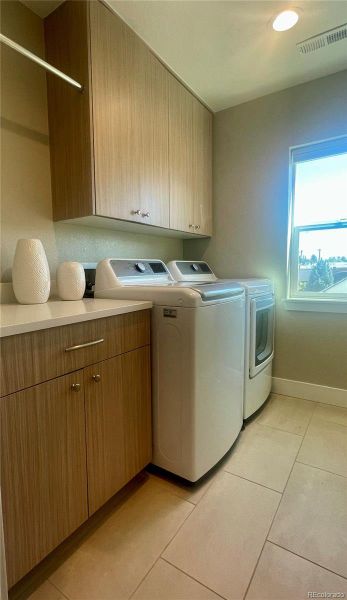 Laundry room on primary suite level, with counter top, cabinets, and hanging rack