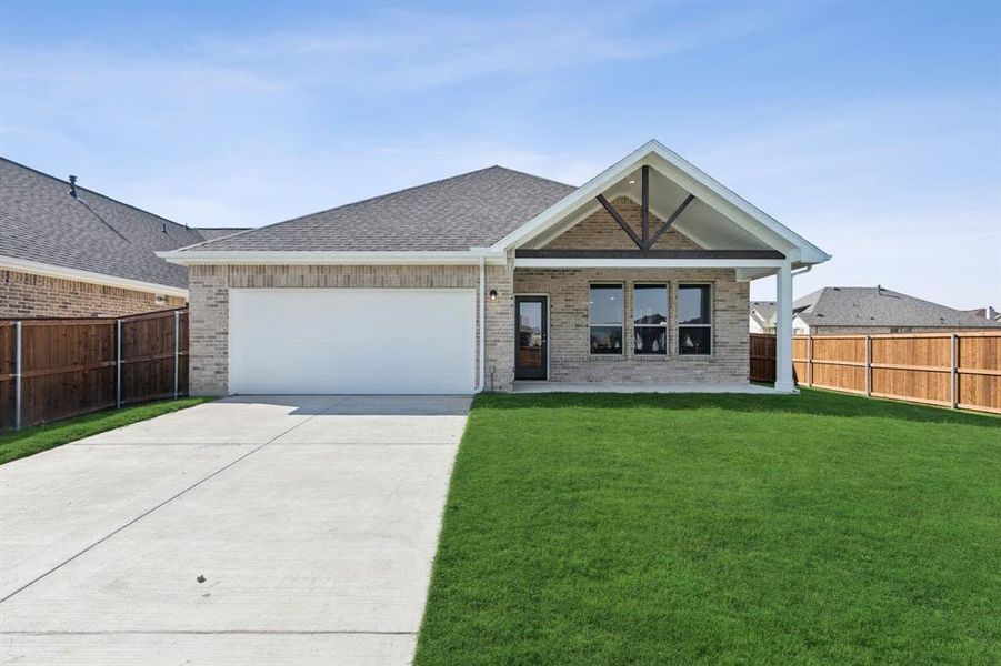 View of front of property with a garage and a front yard