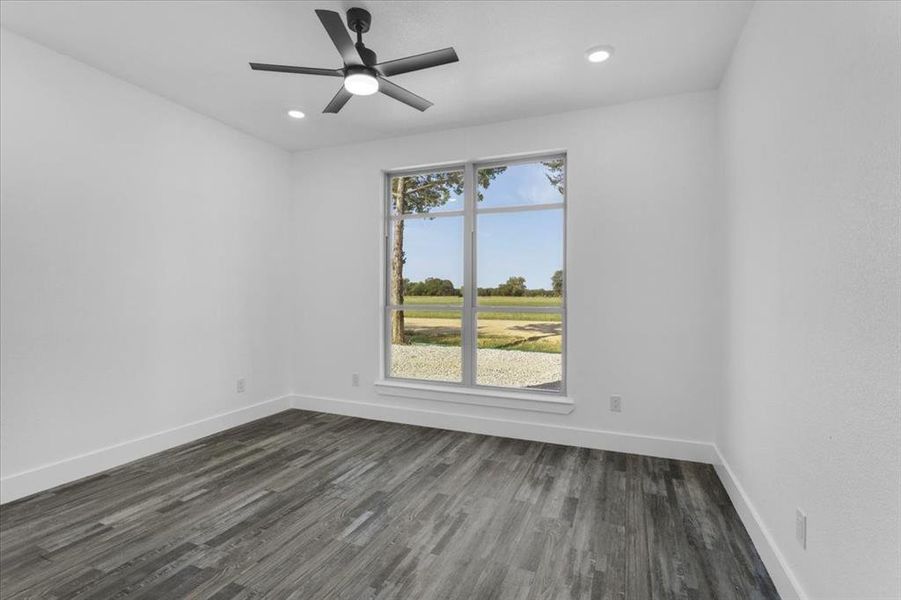 Unfurnished room with ceiling fan and dark hardwood / wood-style flooring