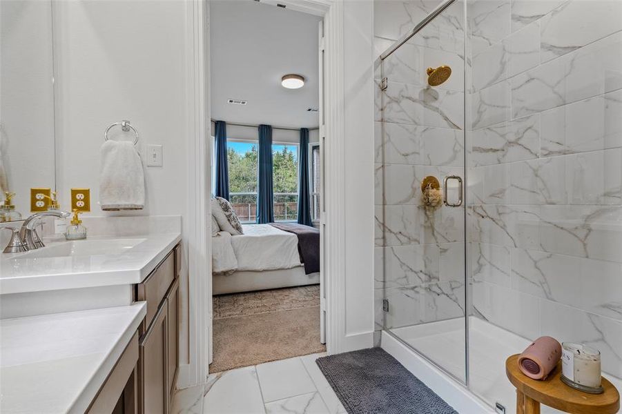 Bathroom featuring a shower with door and vanity